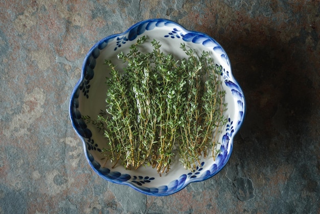 Green thyme in a bowl on slate close up