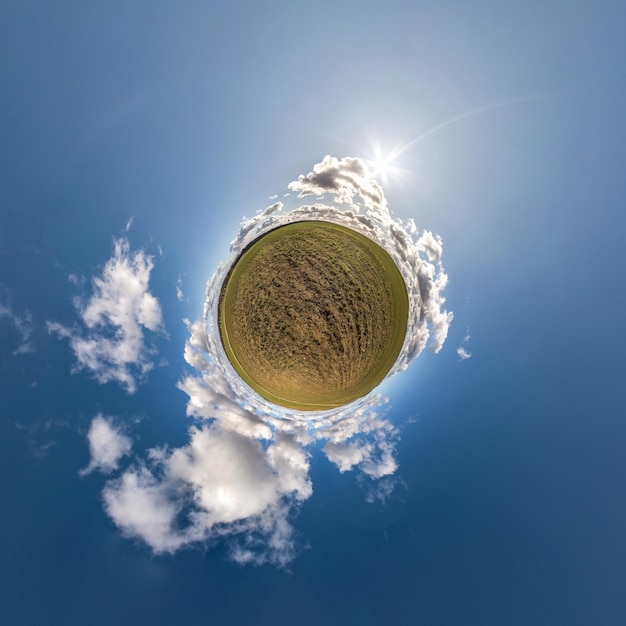 Green tiny planet in blue sky with beautiful clouds Transformation of spherical panorama 360 degrees Spherical abstract aerial view Curvature of space