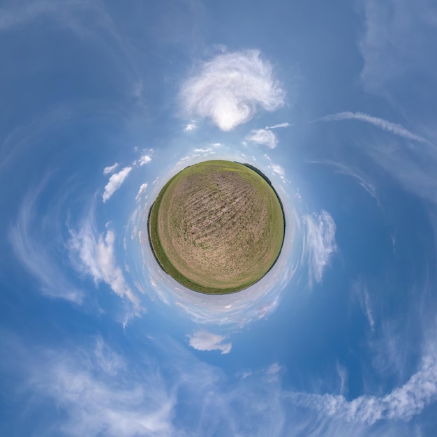 Green tiny planet in blue sky with beautiful clouds
transformation of spherical panorama 360 degrees spherical abstract
aerial view curvature of space