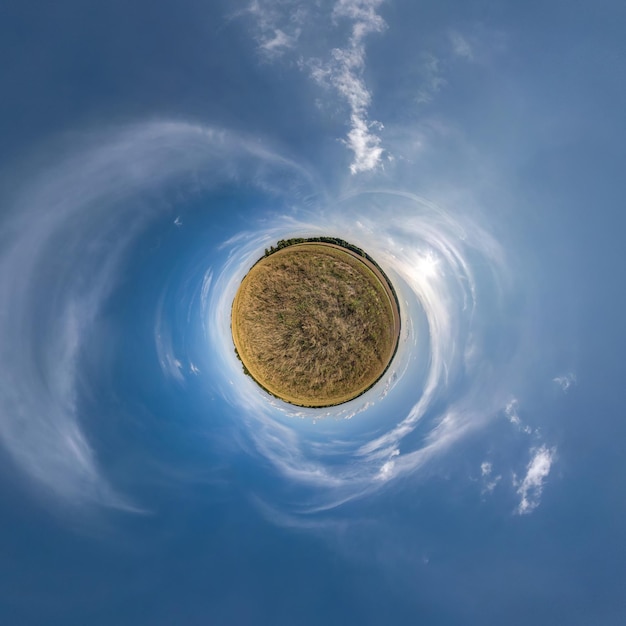 Green tiny planet in blue sky with beautiful clouds with transformation of spherical panorama 360 degrees Curvature of space
