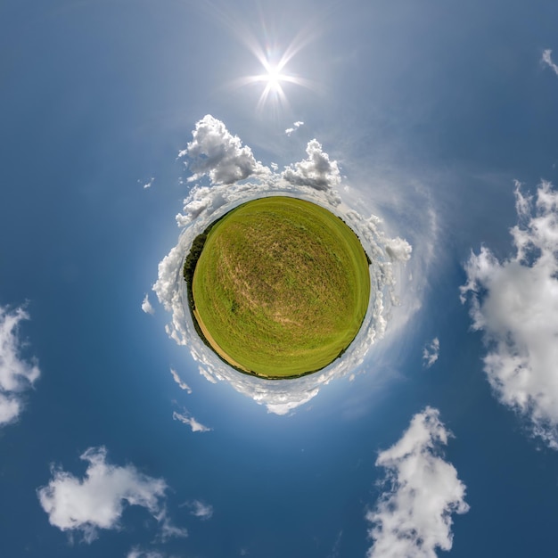 Green tiny planet in blue sky with beautiful clouds with transformation of spherical panorama 360 degrees Curvature of space