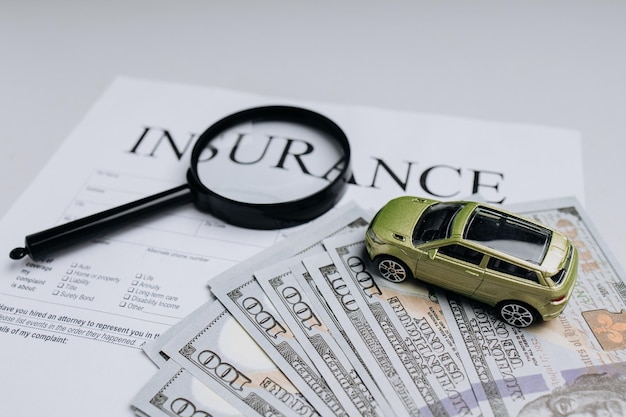 Green toy car with money on an insurance contract Safety concept