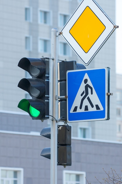 Photo green traffic light, pedestrian crosswalk and main road traffic signs