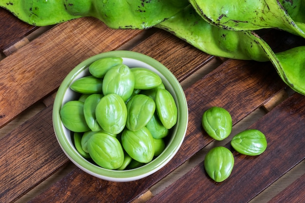 Fagioli commestibili e guaina verdi commestibili tropicali verdi su fondo di legno scuro