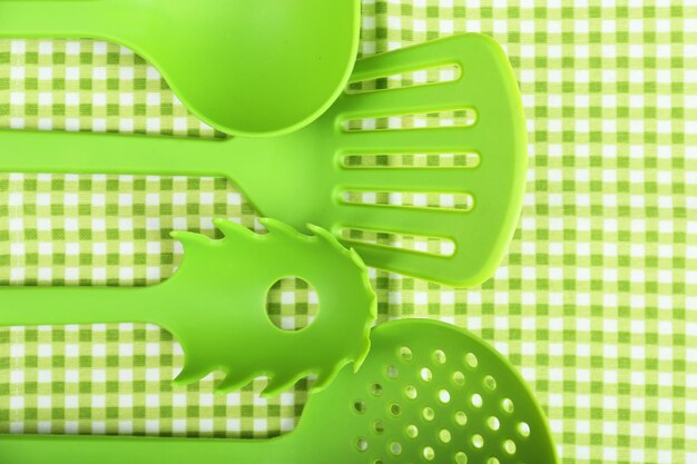 Photo green utensils on gingham textile background