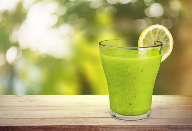 Photo green vegetable smoothie in glass on wooden table