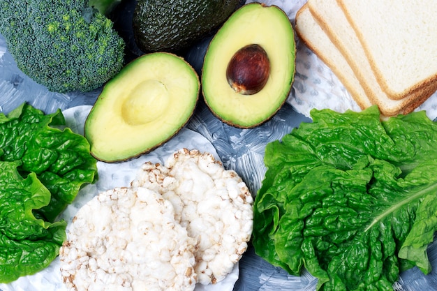 Green vegetables and bread on gray 