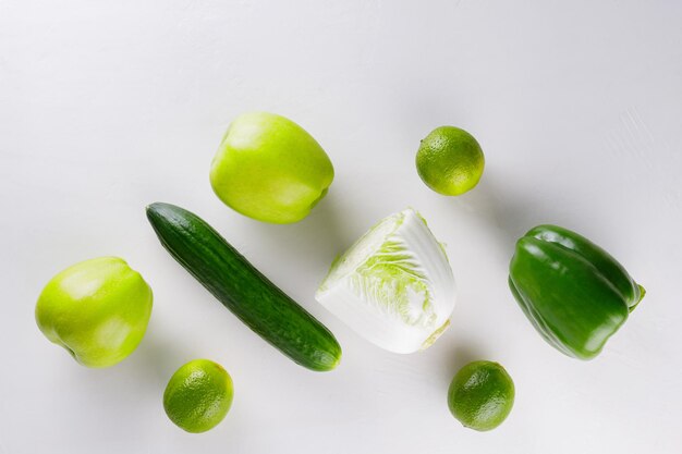 Green vegetables and fruits on white background. healthy vegetarian food concept. top view