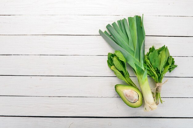 Green vegetables and fruits On a white wooden background Healthy food Top view Copy space