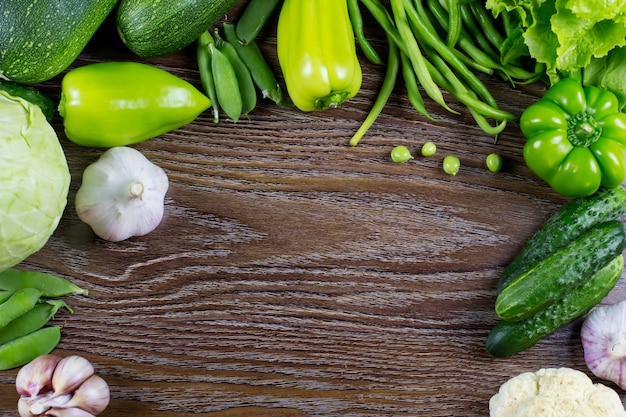 Green vegetables harvest, raw healthy organic food on wooden background