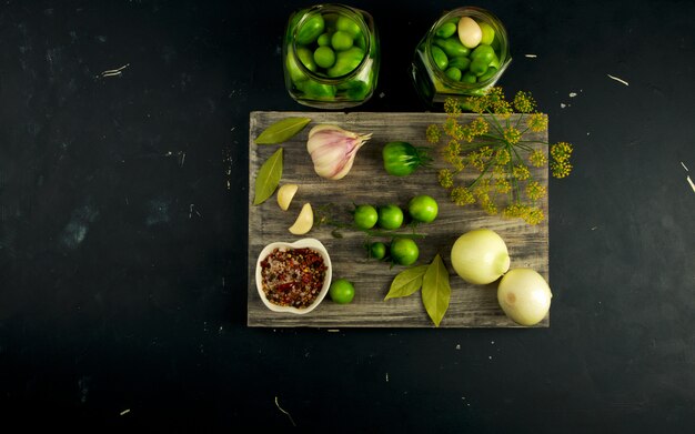 Green vegetables and spices on wooden cutting board