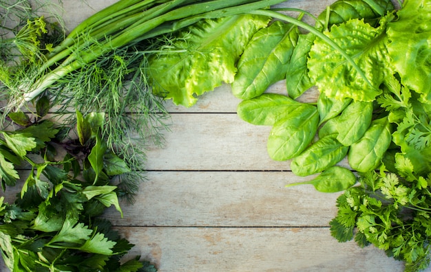 Green vegetables on a wooden background. 