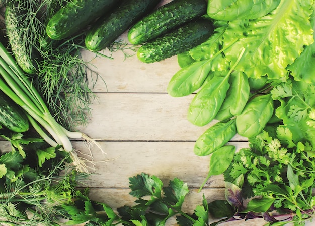 Green vegetables on a wooden background.