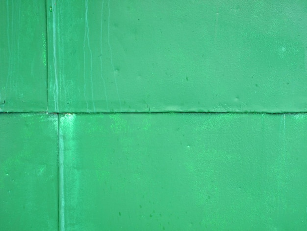 늪 색상의 페인트 질감 배경으로 덮인 녹색 벽 철제 차고 벽
