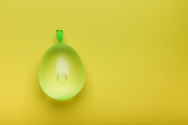 green water balloon on yellow background