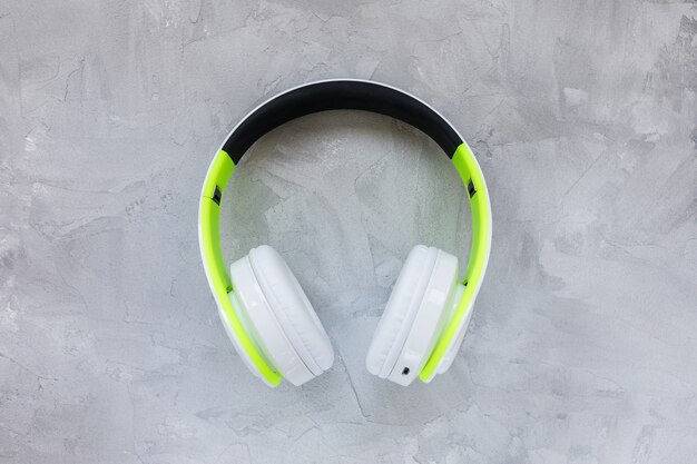 Green and white headphones on gray