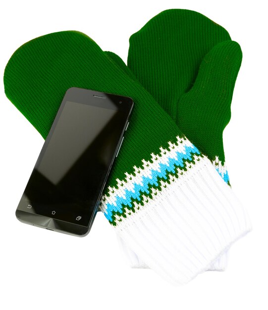 Green and white knited mittens with cellphone isolated on white background