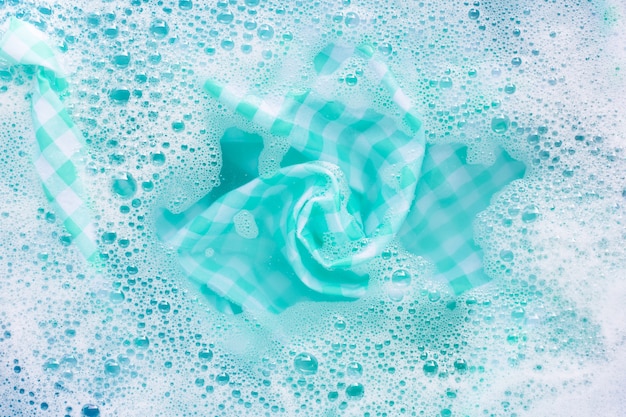 Green white tablecloth soak in powder detergent water dissolution. Laundry concept