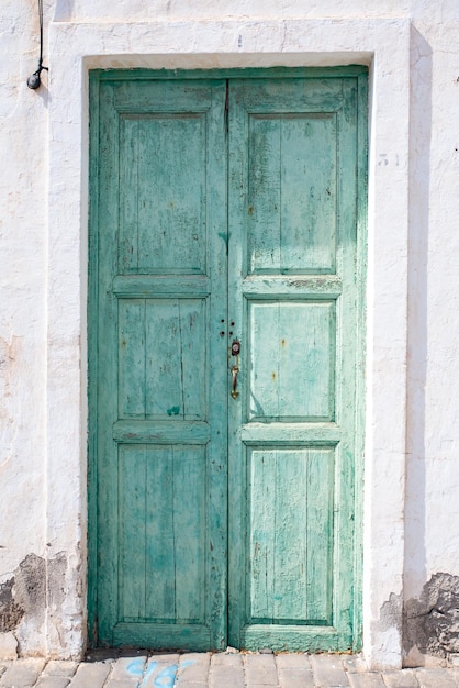 Lanzarote에 있는 Teguise 마을의 전형적인 흰색 집의 녹색 나무 문