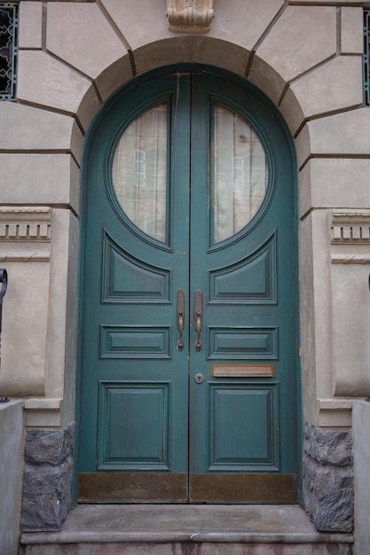 Green wooden door with brick wall