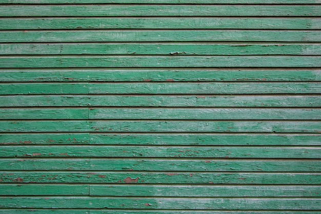 Vecchio bordo graffiato di legno verde con i nodi. struttura del bordo orizzontale in legno.