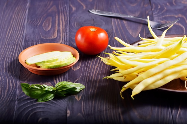 Green and yellow bean pods of asparagus on old rustic wooden table