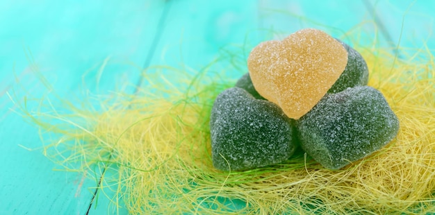 Foto decorazione di zucchero a forma di cuore di caramella di gelatina verde e gialla su uno sfondo luminoso primaverile vacanze san valentino festa della mamma