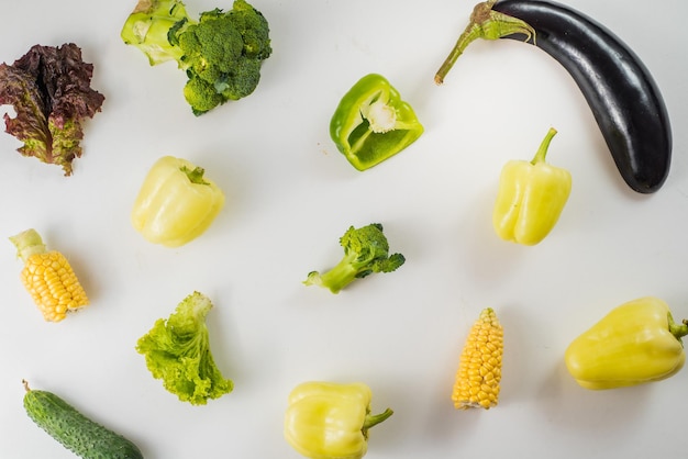 Green and yellow ripe vegetables on white background. Flat lay