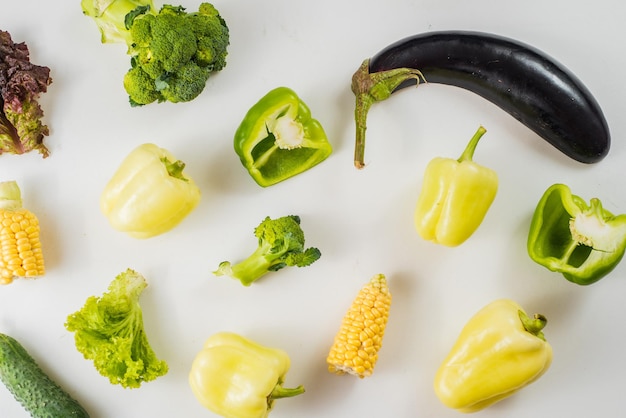 Green and yellow ripe vegetables on white background. Flat lay