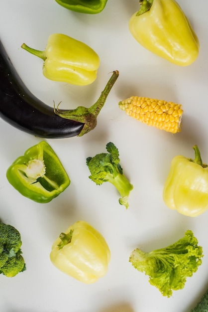 白地に緑と黄色の熟した野菜。フラットレイ