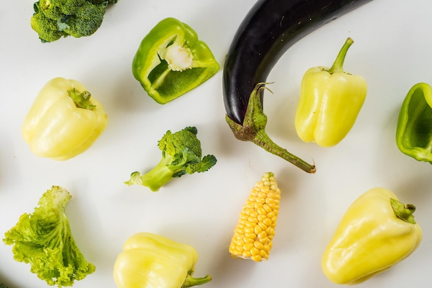 Green and yellow ripe vegetables on white background. Flat lay