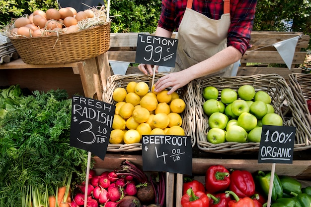 Foto erbivendolo che prepara il prodotto agricolo fresco organico al mercato dell'agricoltore