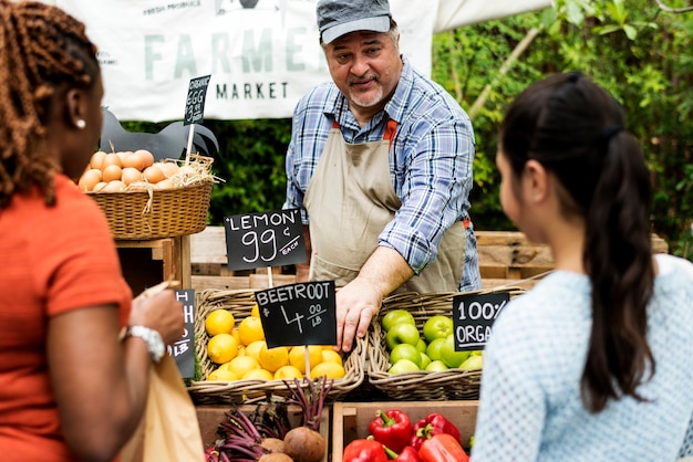 Фото greengrocer продает органический свежий сельскохозяйственный продукт на фермерском рынке