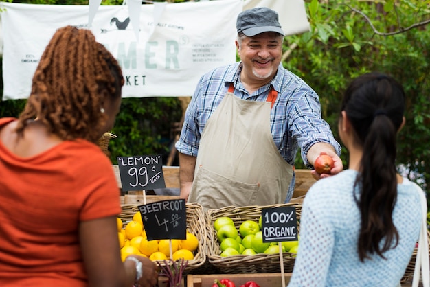 Greengrocer продает органический свежий сельскохозяйственный продукт на фермерском рынке