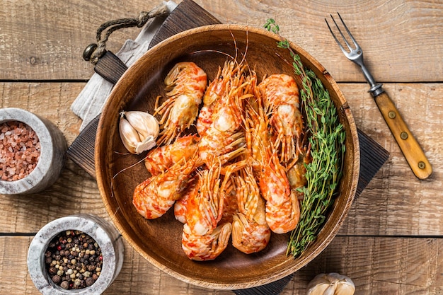 Greenland Shrimps Prawns in a wooden plate with thyme. wooden background. Top view.