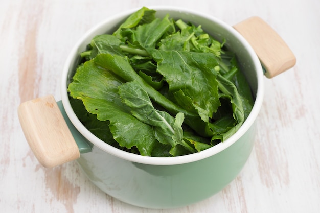 Greens in dish on wooden