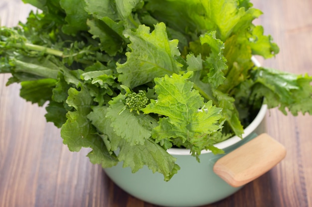 Greens in dish on wooden