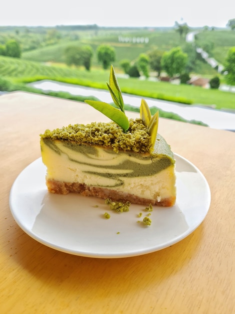 Greentea cheesecake on a white plate on a wooden table