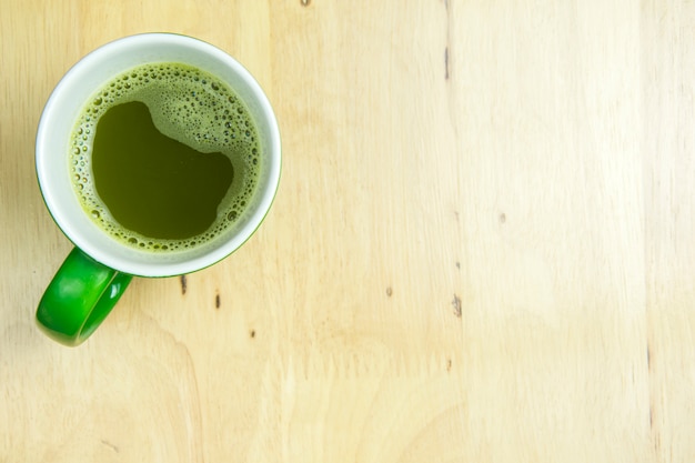 Greentea cup on wooden background. top view, flat lay concept.