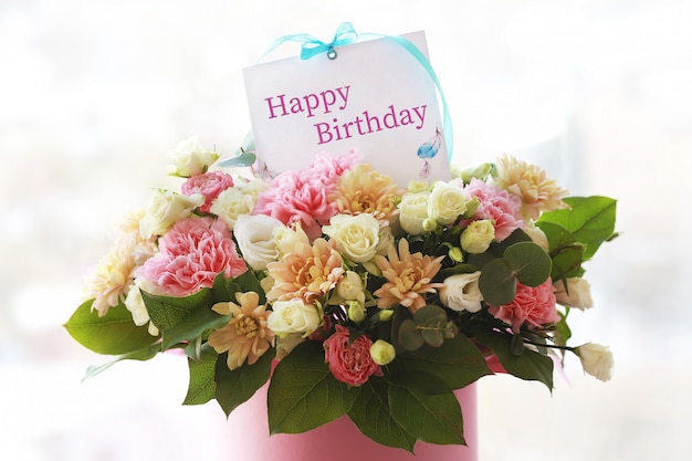 Greeting card in flowers.Congratulatory note.A large beautiful bouquet in a tube with a card.Flowers for a birthday.Bouquet for mother's day.Holiday concept.March 8th.Congratulations on your recovery.