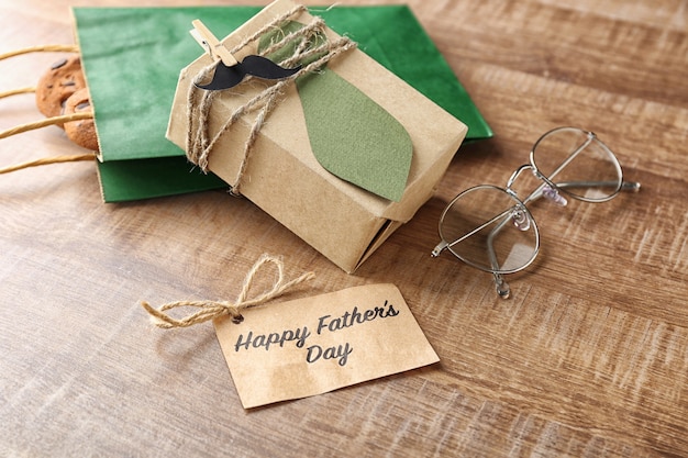 Greeting card, gifts and glasses on wooden table. Father's day composition