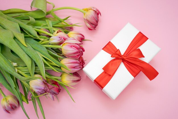 Biglietto di auguri layout bellissimi tulipani e confezione regalo con fiocco rosso su rosa