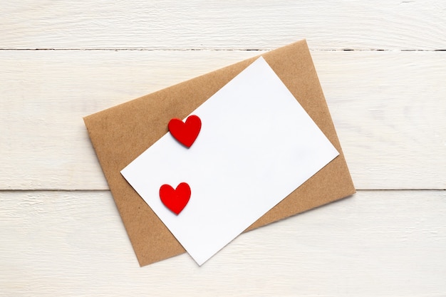 Greeting card template with craft paper envelope and bright red hearts. card text design for social media blogs.