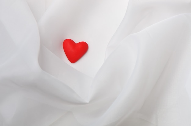 Greeting card for Valentine's Day. Red heart on a white cloth