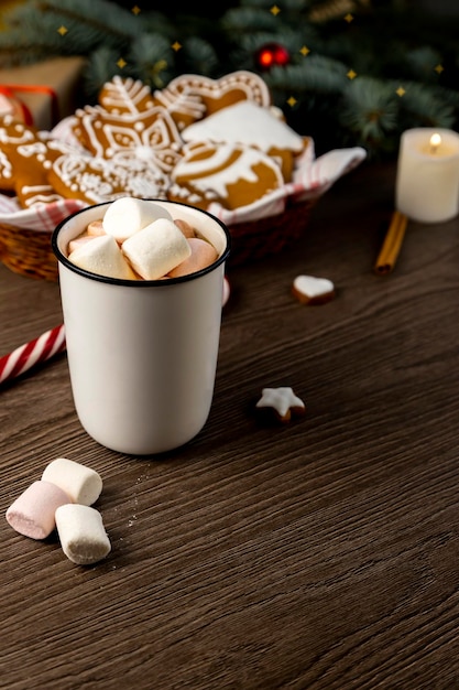 Greeting Christmas card Gingerbread cookies cocoa with marshmallows and a candle on the table Focus on the cup