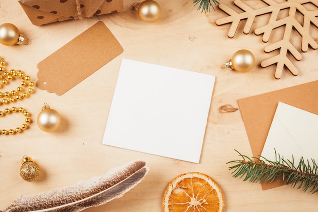 Greeting letter, envelope and feather surrounded by Christmas decorations