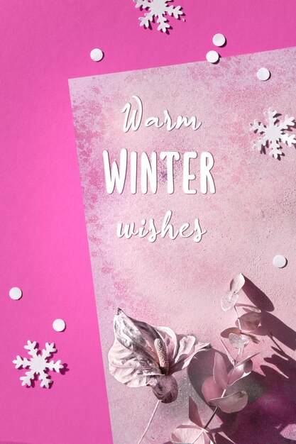 Photo greeting text warm winter wishes abstract flat lay with dry cala lily flower and eucalyptus twig painted metallic pink winter paper snowflakes on magenta metallic pink paper