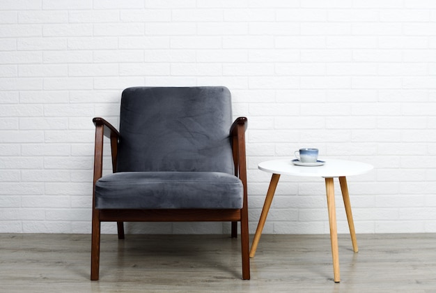 Grey armchair and small table with coffee cup