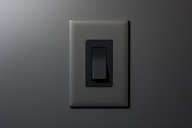 A grey background with a black light switch