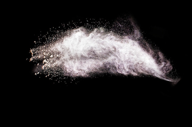 Grey color powder explosion on black background.